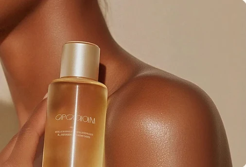 Chai serum màu hổ phách áp lên bờ vai làn da nâu khỏe