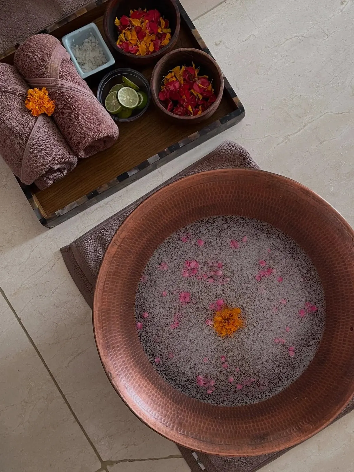 Copper foot bath with flower petals